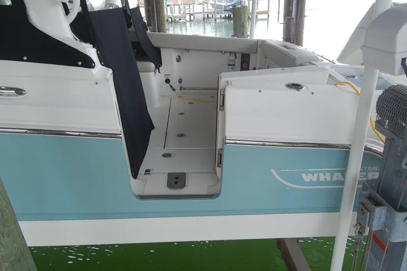 Slide: The Image of 2021 Boston Whaler 280 Vantage boat interior, docked, with blue and white exterior. - 3