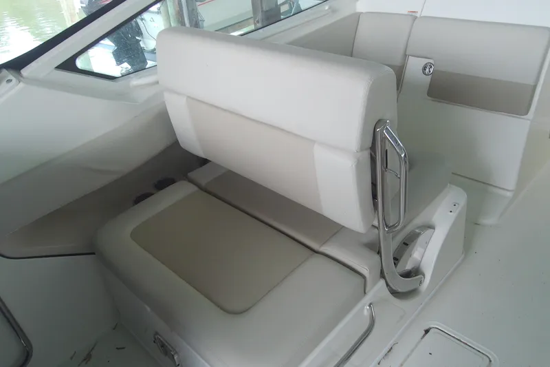 Slide: The Image of 2021 Boston Whaler 280 Vantage interior seating with white upholstery and chrome accents. - 8