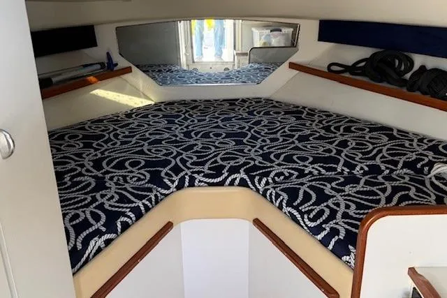 Slide: The Image of 2003 Tiara Yachts 2900 Coronet cabin interior with patterned bedding and storage shelves. - 28