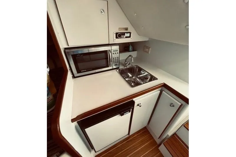 Slide: The Image of Compact galley kitchen in 2003 Tiara Yachts 2900 Coronet, featuring microwave and sink. - 29