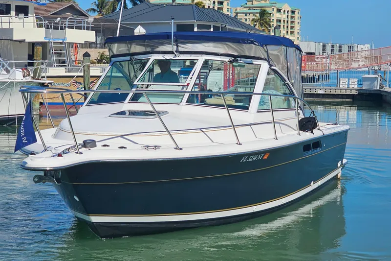 Slide: The Image of 2003 Tiara Yachts 2900 Coronet in marina, calm waters, clear sky, palm trees in background. - 3