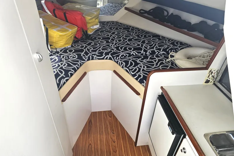 Slide: The Image of 2003 Tiara Yachts 2900 Coronet cabin interior with patterned bedding and safety equipment. - 30