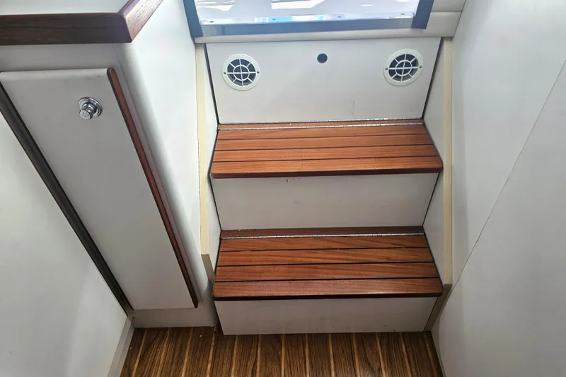 Slide: The Image of Wooden steps inside a 2003 Tiara Yachts 2900 Coronet, featuring sleek design and ventilation. - 35