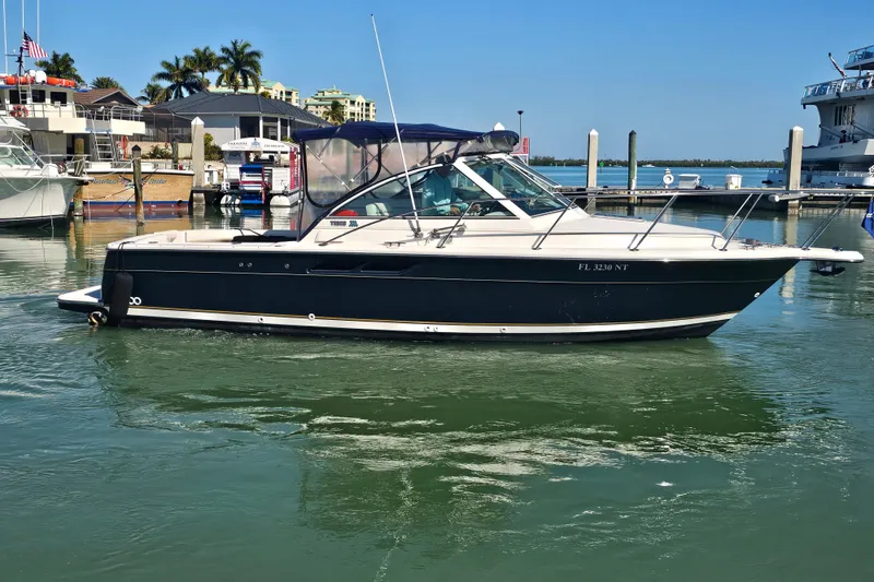 Slide: The Image of 2003 Tiara Yachts 2900 Coronet boat docked in a marina under clear blue skies. - 5