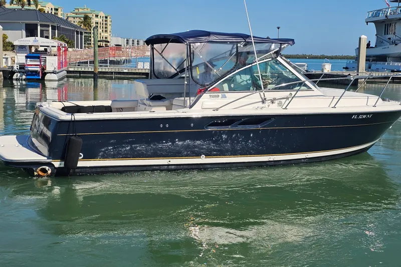 Slide: The Image of 2003 Tiara Yachts 2900 Coronet docked in a marina under clear blue skies. - 6
