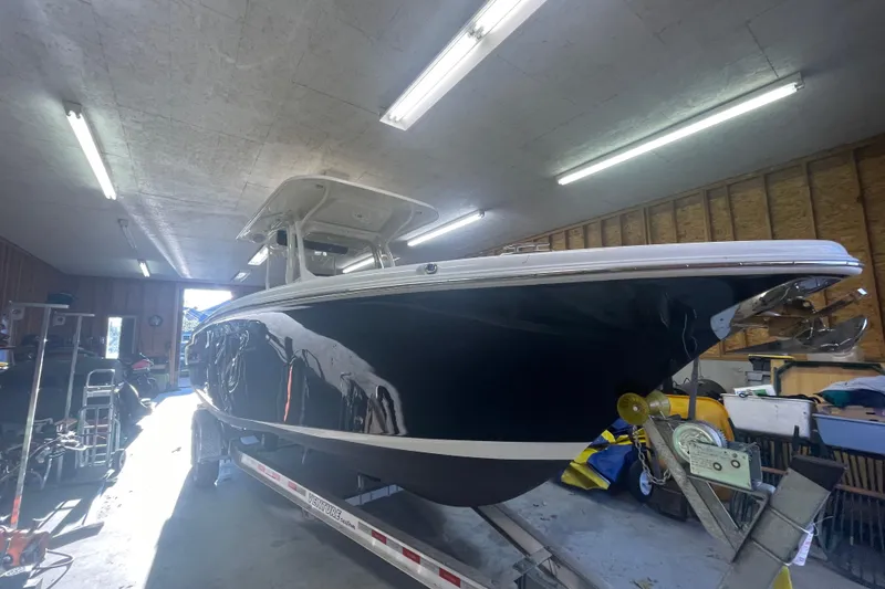 Slide: The Image of 2023 Key West 263 FS boat in a well-lit garage on a trailer. - 13