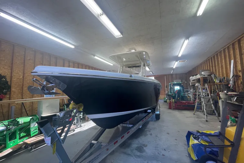 Slide: The Image of 2023 Key West 263 FS boat in a well-lit garage on a trailer. - 14