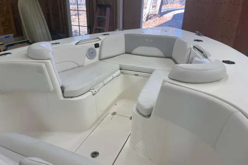 Slide: The Image of 2023 Key West 263 FS boat interior with white cushioned seating in a garage setting. - 18