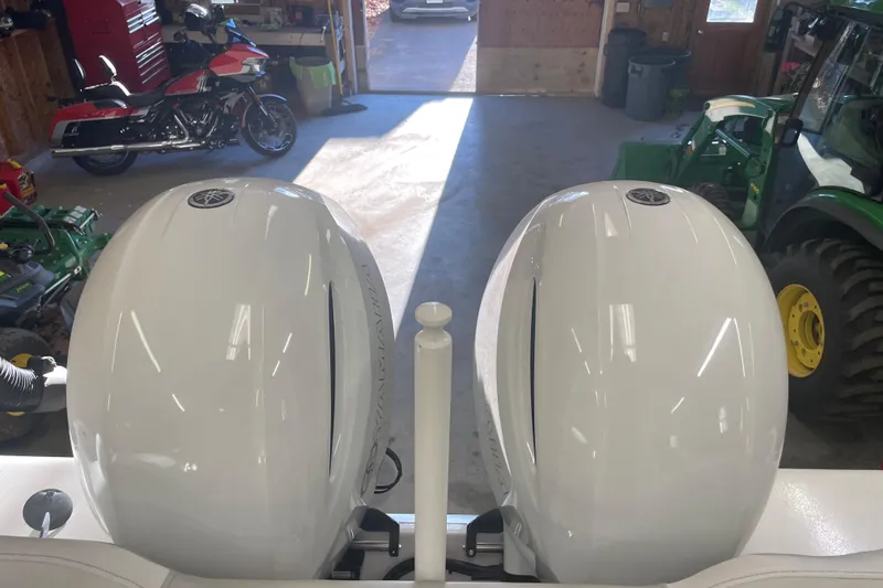 Slide: The Image of 2023 Key West 263 FS boat engines in a garage with motorcycle and tractor. - 22