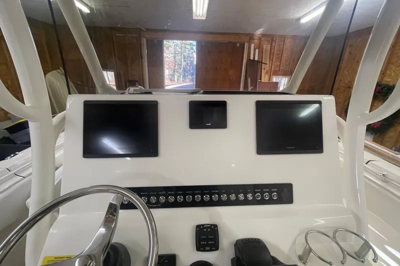 Slide: The Image of 2023 Key West 263 FS boat dashboard with dual screens and control panel in a garage. - 25