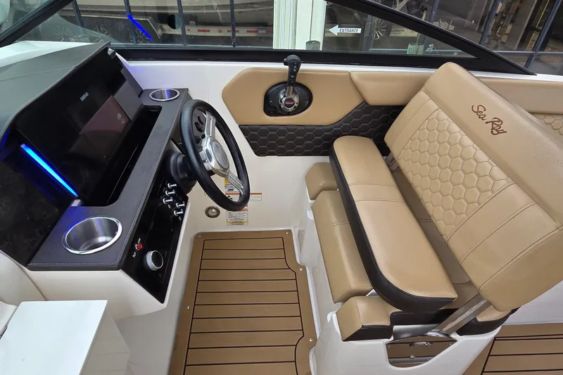 Slide: The Image of 2020 Sea Ray SDX 250 Outboard cockpit with tan seating and modern dashboard. - 13