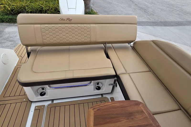 Slide: The Image of 2020 Sea Ray SDX 250 Outboard boat interior with tan seating and wooden accents. - 17