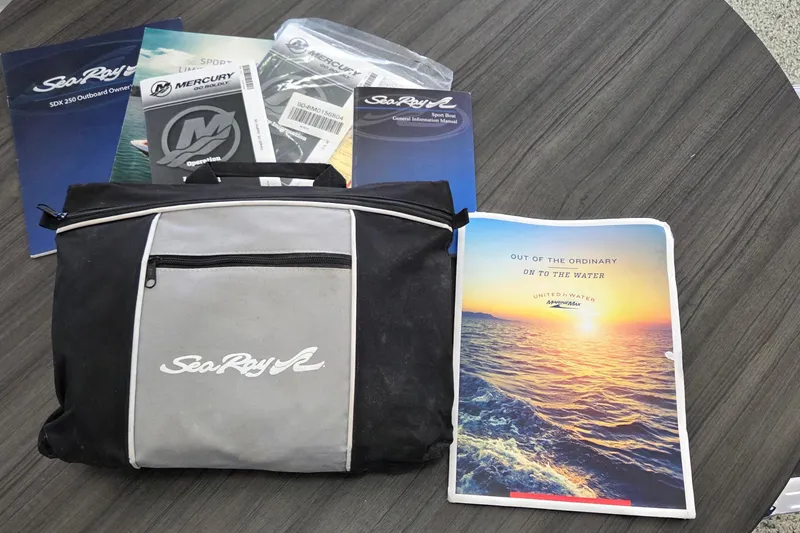 Slide: The Image of Bag and manuals for 2020 Sea Ray SDX 250 Outboard boat on table. - 20