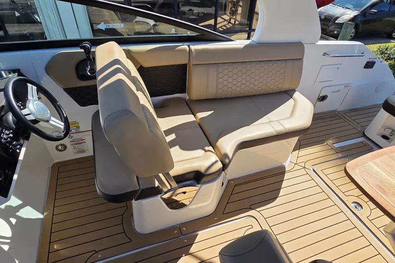Slide: The Image of 2020 Sea Ray SDX 250 Outboard interior with tan seating and wood-style flooring. - 24