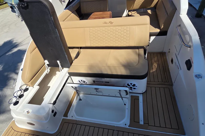 Slide: The Image of 2020 Sea Ray SDX 250 Outboard interior with tan seating and storage compartments. - 28