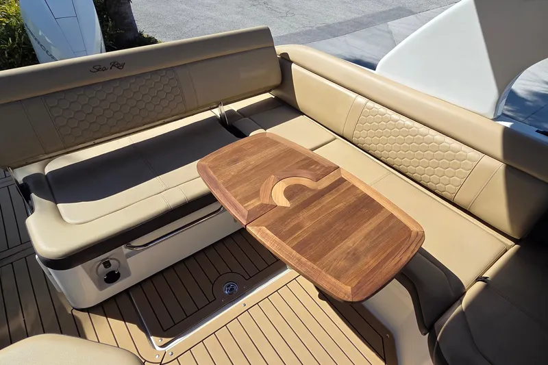 Slide: The Image of 2020 Sea Ray SDX 250 Outboard boat interior with beige seating and wooden table. - 30