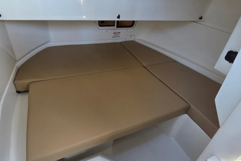 Slide: The Image of 2020 Sea Ray SDX 250 Outboard cabin interior with beige cushions. - 32