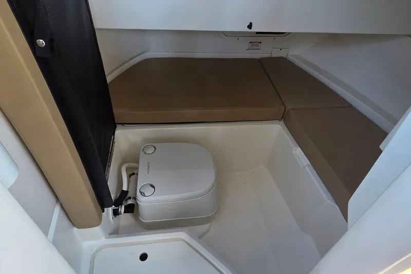 Slide: The Image of 2020 Sea Ray SDX 250 Outboard cabin interior with portable toilet and seating area. - 33
