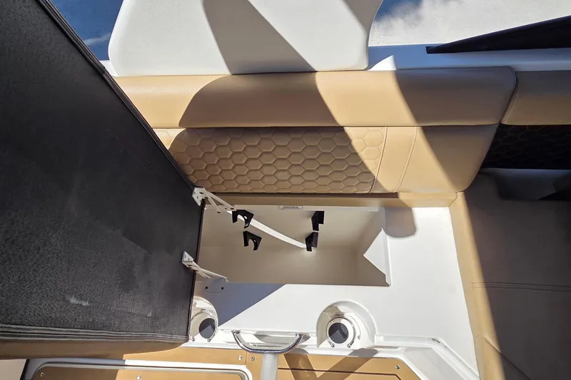 Slide: The Image of 2020 Sea Ray SDX 250 Outboard storage compartment with beige seating and hexagonal pattern. - 35