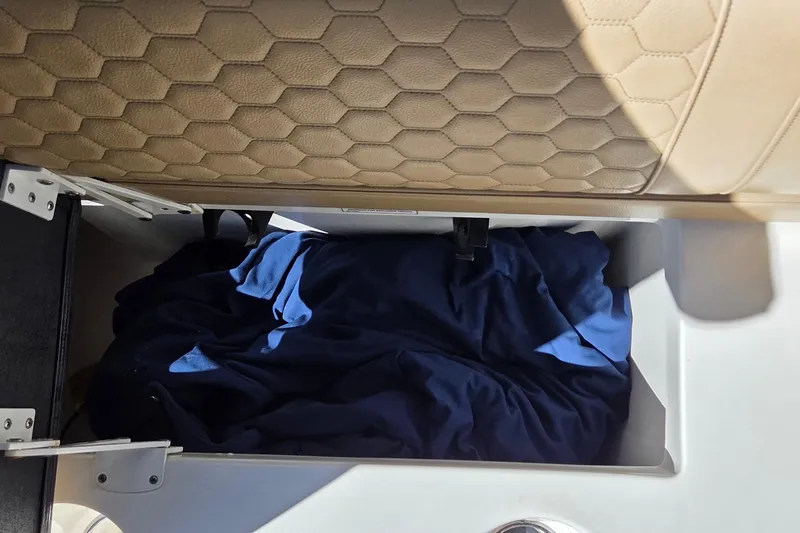 Slide: The Image of Storage compartment in 2020 Sea Ray SDX 250 Outboard with blue fabric inside. - 36