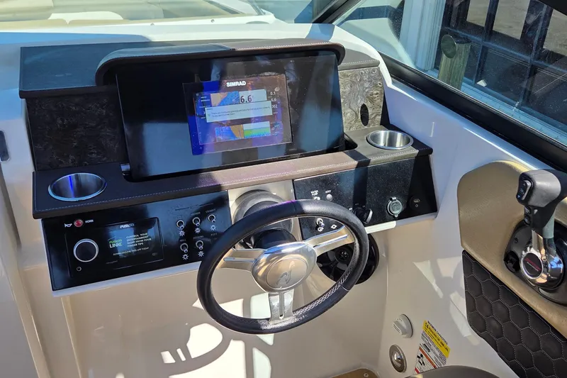 Slide: The Image of 2020 Sea Ray SDX 250 Outboard helm with steering wheel, controls, and navigation display. - 41