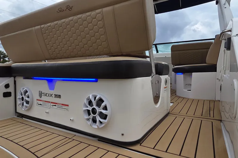 Slide: The Image of 2020 Sea Ray SDX 250 Outboard interior with tan seating and blue LED lighting. - 5