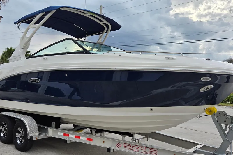 Slide: The Image of 2020 Sea Ray SDX 250 Outboard boat on trailer, blue and white design, parked outdoors. - 8