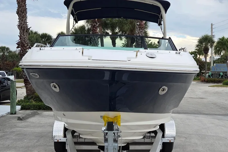 Slide: The Image of 2020 Sea Ray SDX 250 Outboard boat on trailer, parked near palm trees. - 9