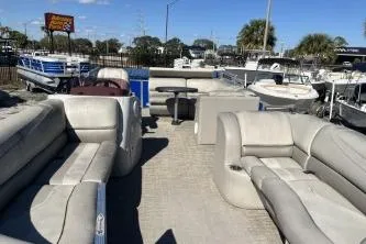 Slide: The Image of 2022 Cypress Cay Seabreeze 232 pontoon boat with spacious seating, docked under clear skies. - 8