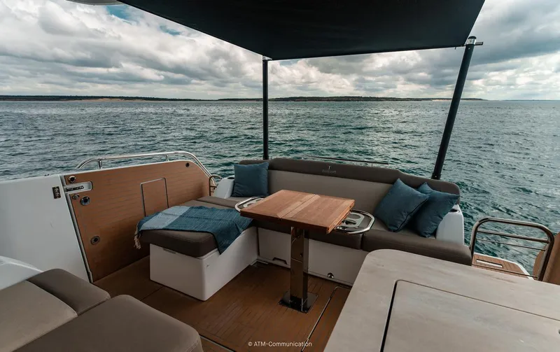 Slide: The Image of 2026 Wellcraft 44 Explorer yacht interior with ocean view, featuring seating and table. - 6