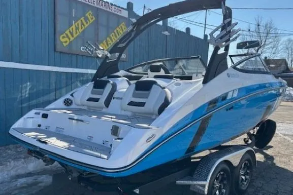 Slide: The Image of 2021 Yamaha Boats 212XD in blue and white, displayed outdoors on a trailer. - 2