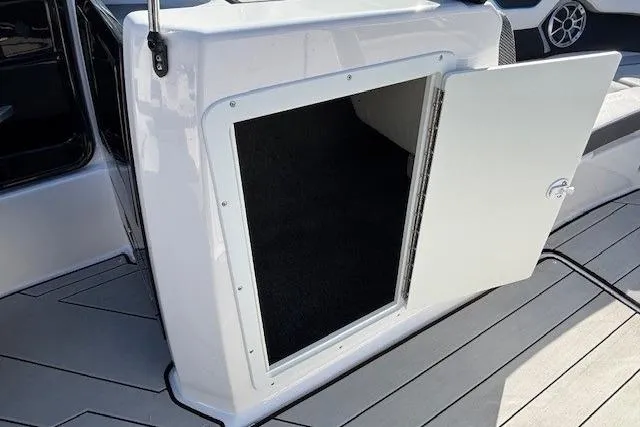 Slide: The Image of 2021 Yamaha Boats 212XD storage compartment with open door on deck. - 20