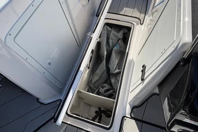 Slide: The Image of Open storage compartment on 2021 Yamaha Boats 212XD, showcasing interior space and equipment. - 23
