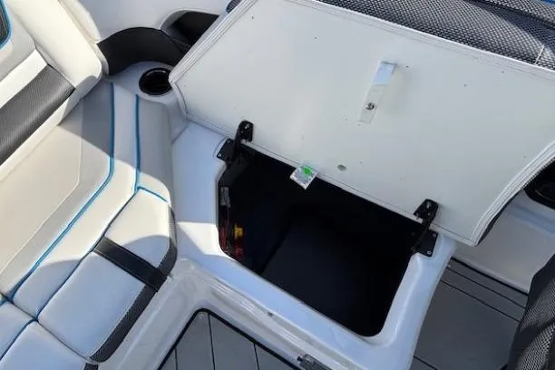 Slide: The Image of 2021 Yamaha Boats 212XD interior storage compartment with open lid and seating area. - 26
