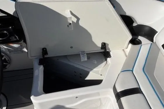Slide: The Image of Open storage compartment on 2021 Yamaha Boats 212XD, featuring white interior and seating. - 28