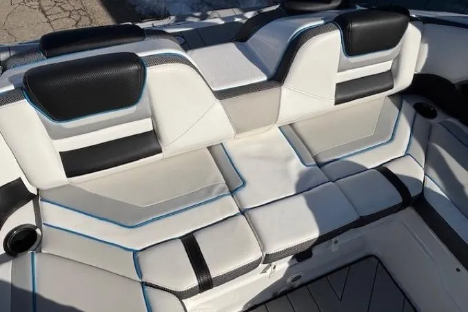 Slide: The Image of 2021 Yamaha Boats 212XD interior seating with black and white upholstery, featuring blue accents. - 29