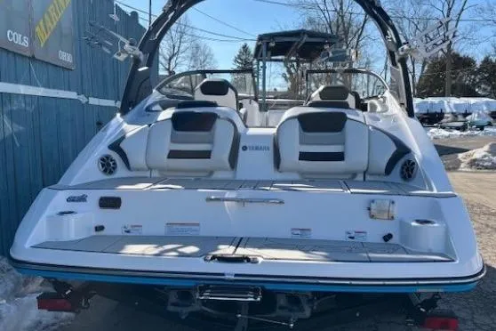 Slide: The Image of 2021 Yamaha Boats 212XD, rear view, white and black design, parked outdoors. - 3