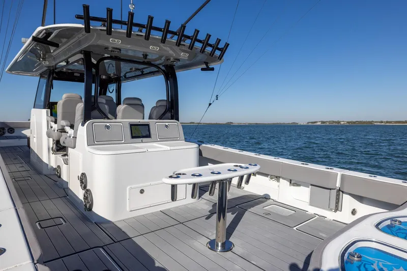 Slide: The Image of 2024 Freeman 47 boat interior with modern seating and fishing rod holders on open water. - 16