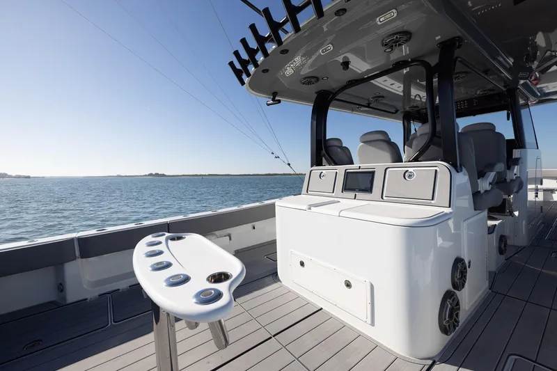 Slide: The Image of 2024 Freeman 47 boat interior with fishing rod holders and seating, on calm water. - 18