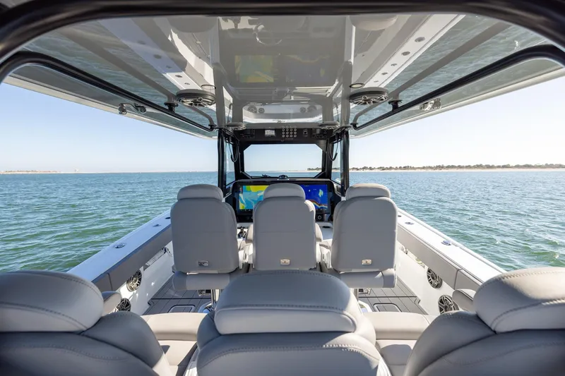 Slide: The Image of Interior view of 2024 Freeman 47 boat, featuring modern seating and ocean backdrop. - 22