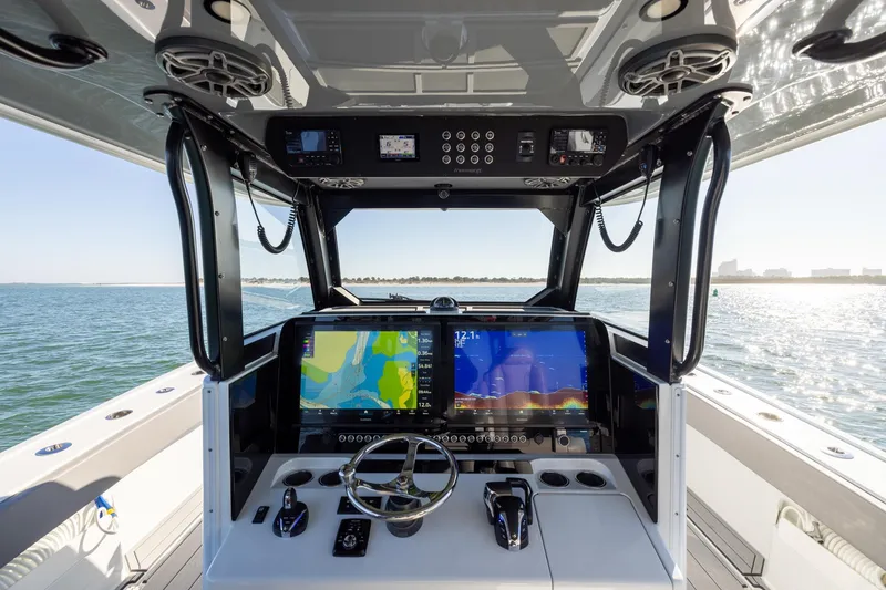 Slide: The Image of 2024 Freeman 47 boat cockpit with advanced navigation systems on open water. - 27