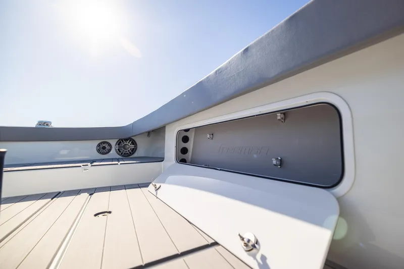 Slide: The Image of 2024 Freeman 47 boat interior with open storage compartment and speakers under sunny sky. - 42