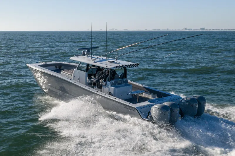 Slide: The Image of 2024 Freeman 47 boat cruising on open water with fishing rods and powerful engines. - 48