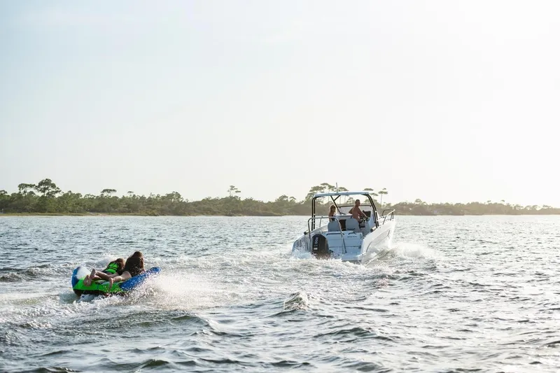Slide: The Image of 2026 Beneteau Flyer 8 SUNdeck towing inflatable on open water. - 13