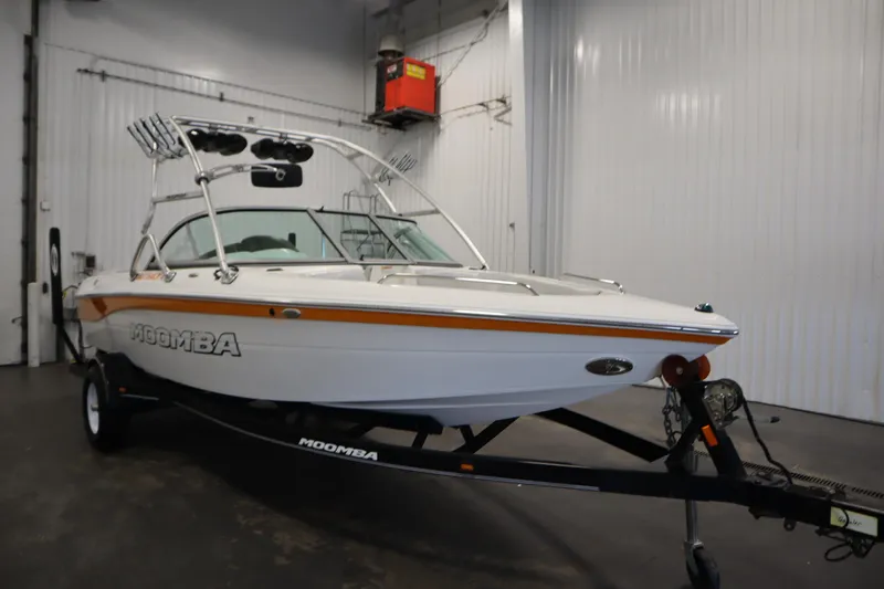 Slide: The Image of 2008 Moomba Outback V boat in a garage, featuring a sleek design and trailer. - 3