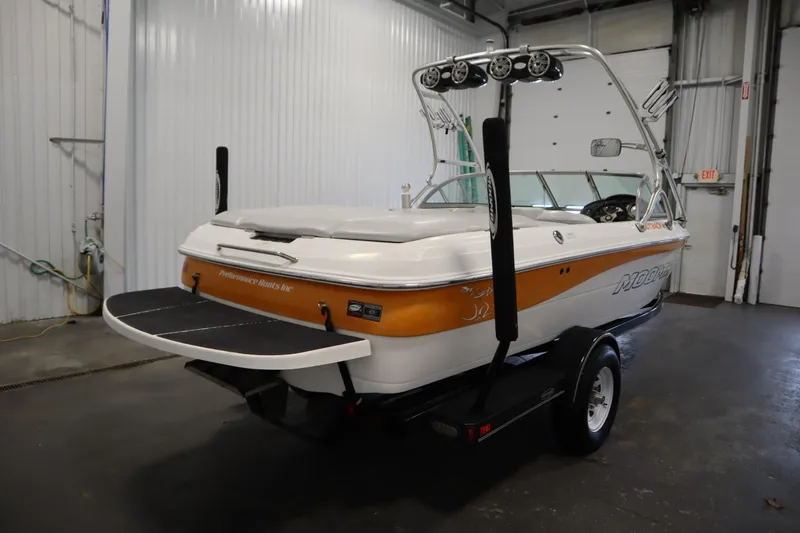 Slide: The Image of 2008 Moomba Outback V boat in a garage, featuring a sleek design and vibrant colors. - 5