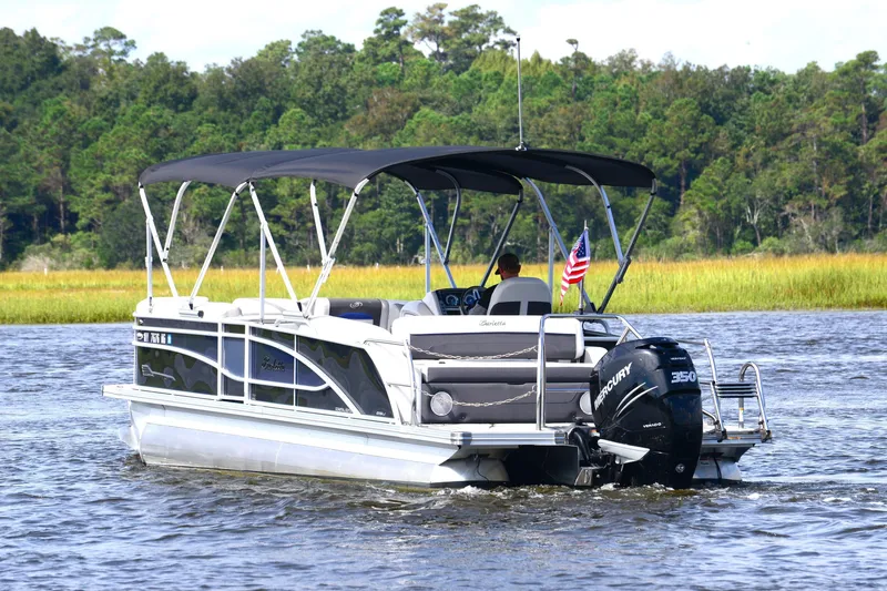 The Image of 2022 Barletta Corsa 25U pontoon boat cruising on a scenic lake. - 1