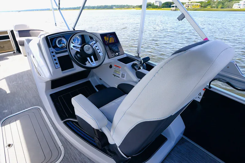 Slide: The Image of 2022 Barletta Corsa 25U boat cockpit with steering wheel and control panel on water. - 10