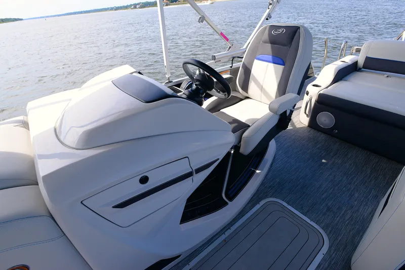 Slide: The Image of 2022 Barletta Corsa 25U boat interior with steering wheel and seating on water. - 21