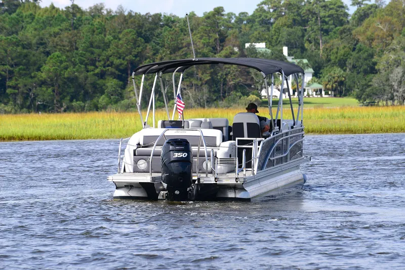 Slide: The Image of 2022 Barletta Corsa 25U pontoon boat cruising on a scenic river. - 3